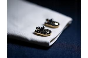 Cufflinks perak dengan ukiran detail dan batu mulia.